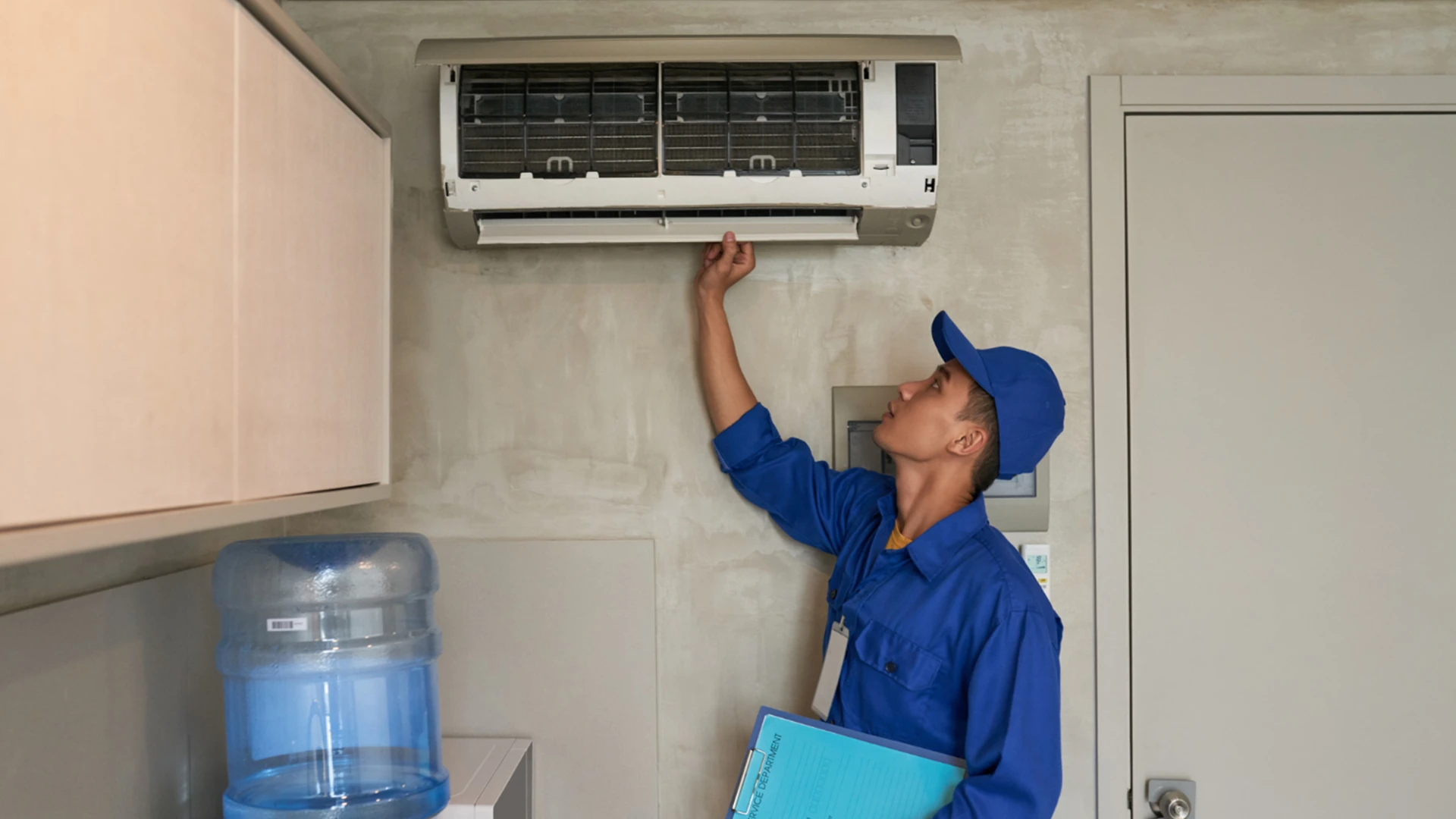 Technician inspecting and servicing an air conditioner unit as part of home maintenance services in Dubai.