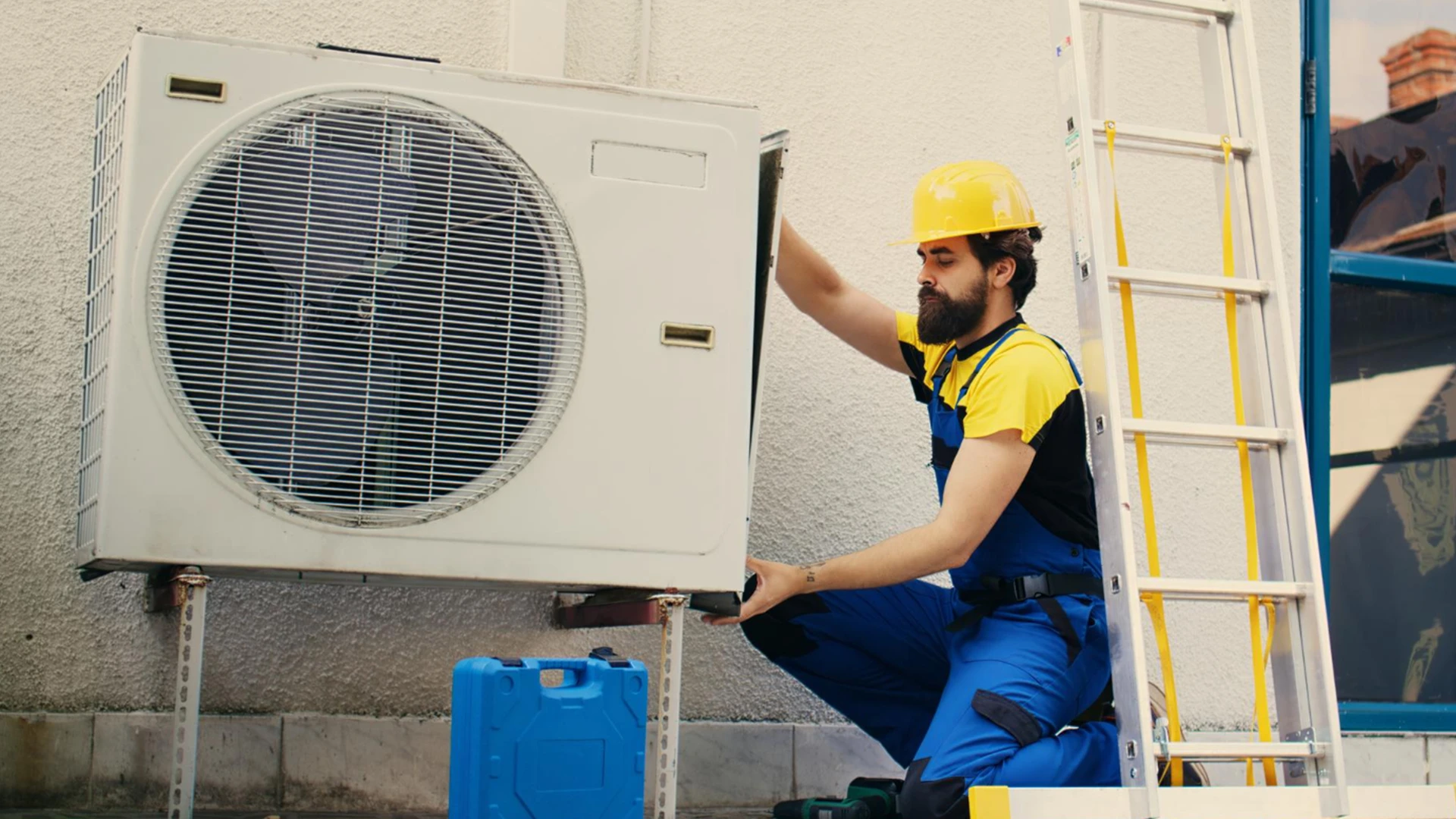 Technician performing AC maintenance services in Dubai on an outdoor air conditioning unit with tools and safety equipment.