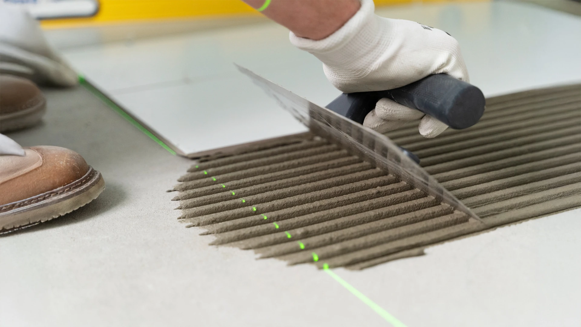 Close-up of expert tile installation during home repair services in Dubai.