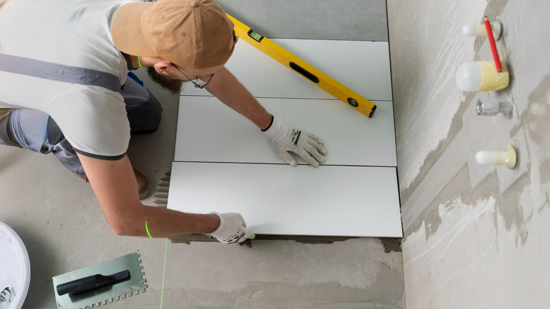 Flooring expert providing flooring services in Dubai by laying large ceramic tiles in a residential space.