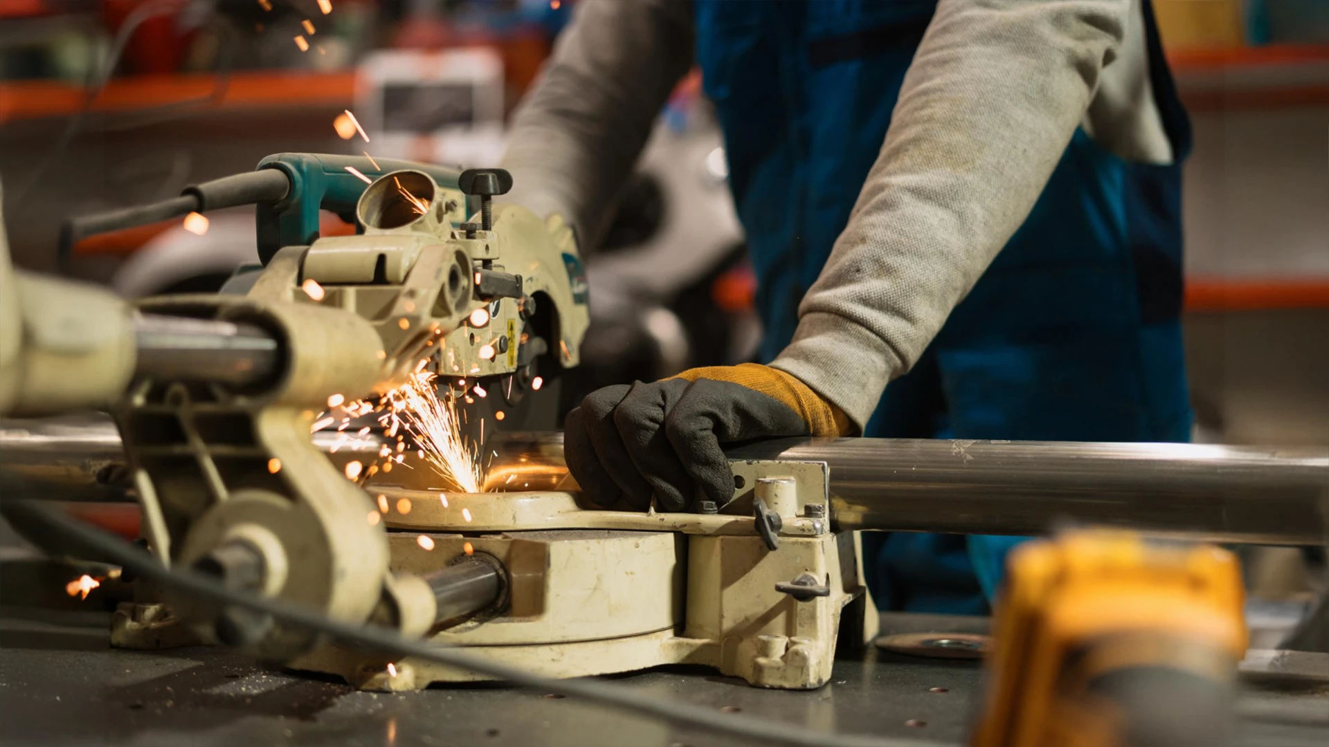 Technician performing iron and SS fabrication service in Dubai using precision metal cutting equipment.