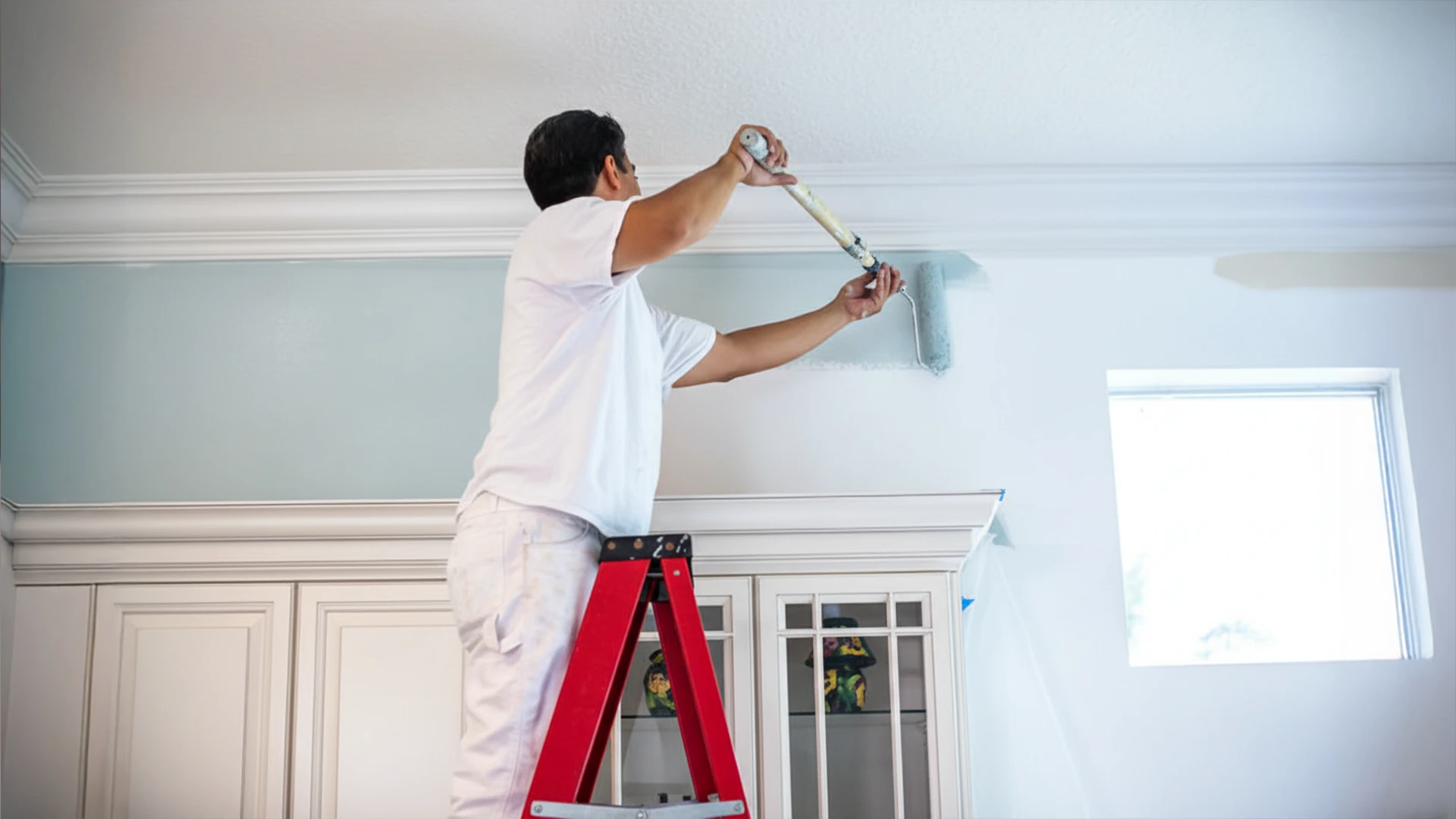 Professional applying paint to interior walls during wall painting services in Dubai.